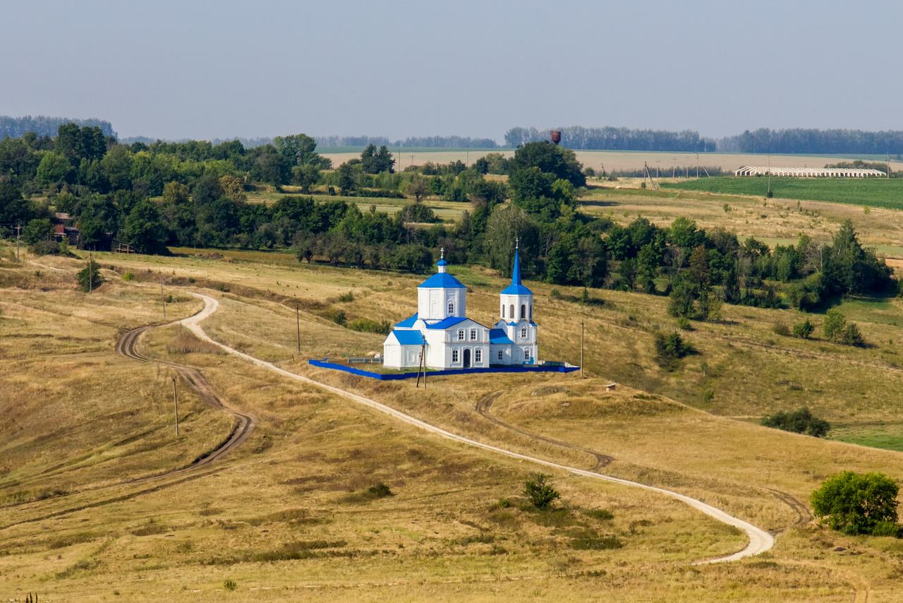 Просёлочная дорога ведёт к церкви на холме среди полей